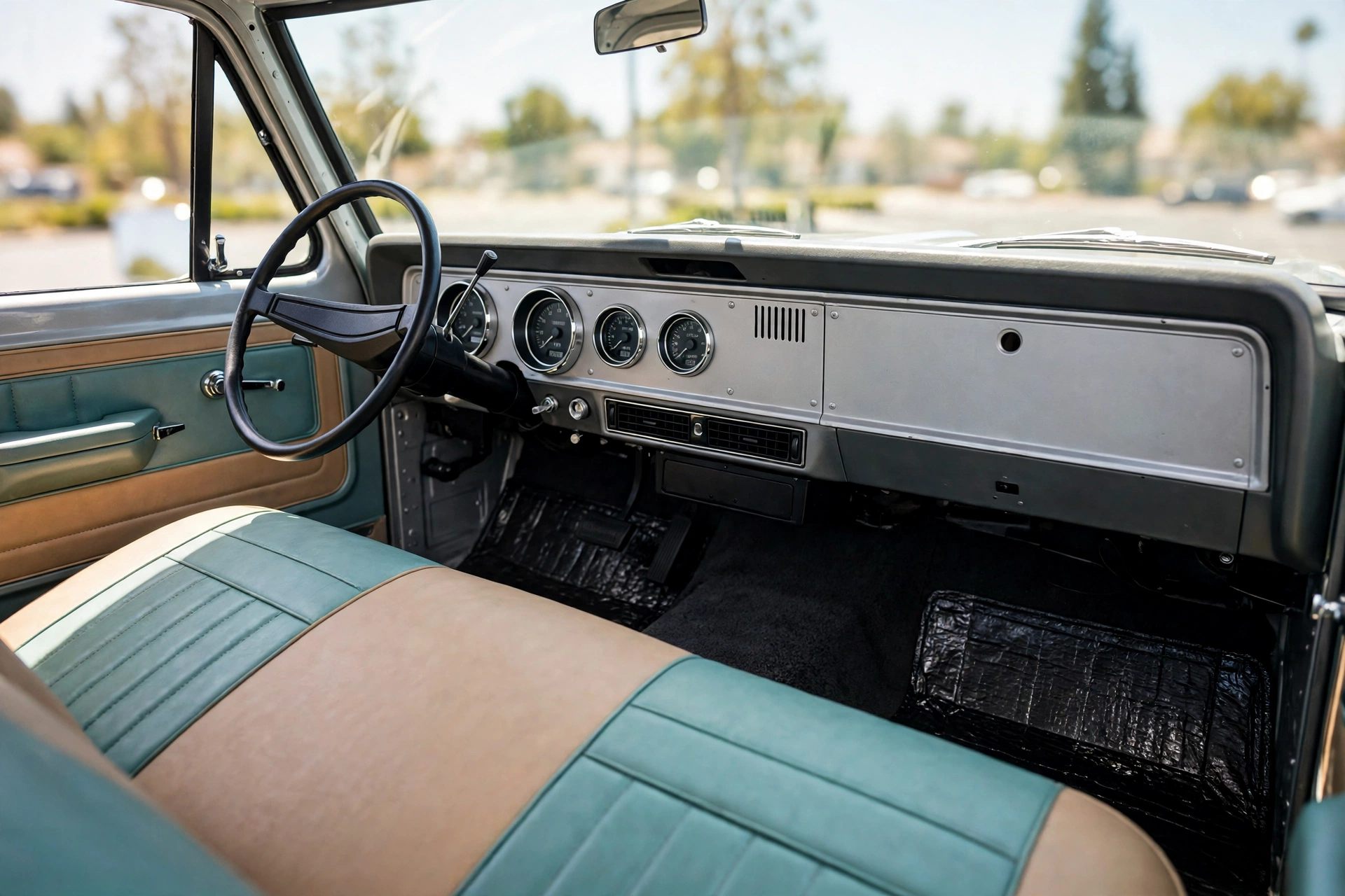 Restored bumpside F-100 interior with stock-look modern gauges, under-dash A/C vents and a fresh two-tone bench seat